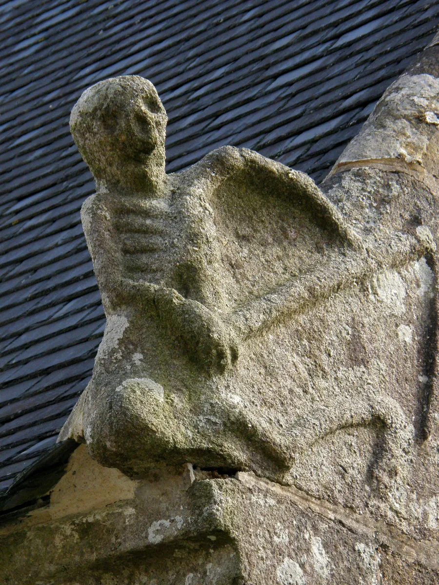L'Ankou sculpté sur le pignon de l'ossuaire de Brasparts (Finistère), faux en main.