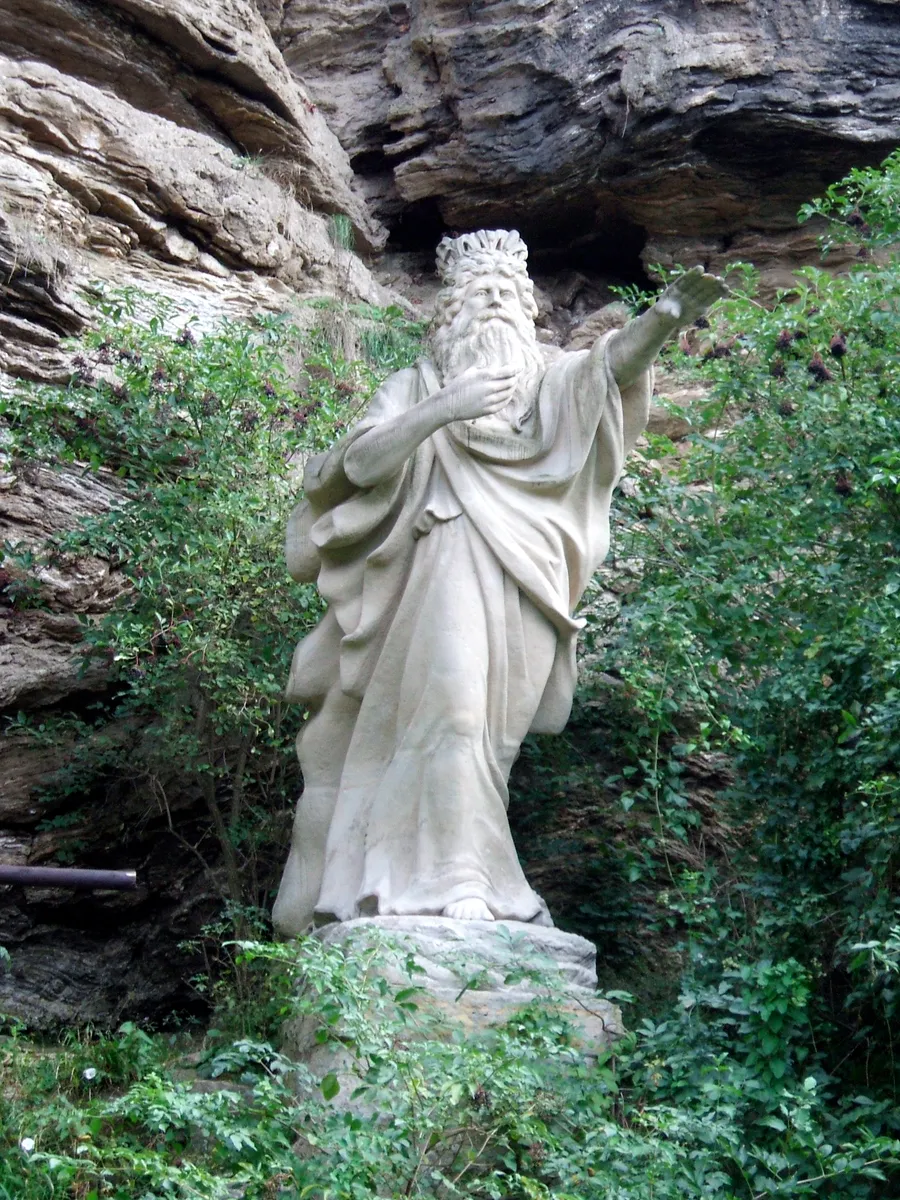 Le monument de l'Erlkönig dans la prairie de la Saale, à Iéna : un vieillard de grès qui tend la main au-dessus de l'étang.