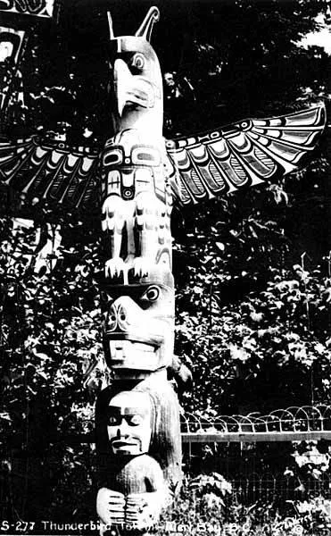 Mât totémique kwakwaka'wakw surmonté d'un oiseau-tonnerre, Alert Bay, Colombie-Britannique, vers 1915.